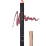 A pink nude INIKA Organic Lip Crayons 6.7g with a gold cap stands upright, a swatch of the shade behind it. This organic lip crayon doubles as a long-lasting liner. Text below says Pink Nude.