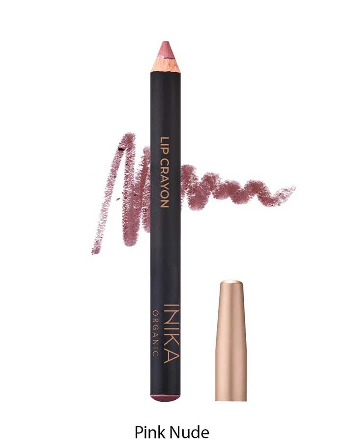 A pink nude INIKA Organic Lip Crayons 6.7g with a gold cap stands upright, a swatch of the shade behind it. This organic lip crayon doubles as a long-lasting liner. Text below says Pink Nude.