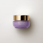 Small low purple 15 ml jar of KORA Plant Stem Cell Retinol Alternative Moisturiser with a wide gold lid, lying on a warm grey surface.