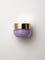 Small low purple 15 ml jar of KORA Plant Stem Cell Retinol Alternative Moisturiser with a wide gold lid, lying on a warm grey surface.