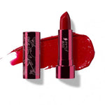 A tube of 100% Pure Fruit Pigmented® Pomegranate Oil Moisturising Lipstick 4.5g in bright blood red, cap off to reveal the bullet. The floral cap and a smear of color are visible. Text: Poppy (a bright, blood red), by 100% Pure.