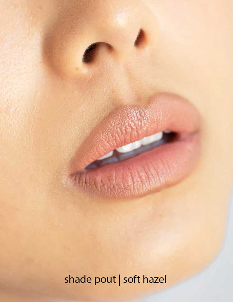 Close-up of lips wearing Ere Perez Acai Lip Pencil in a soft hazel shade, paired with hydrating lipstick for a flawless finish. Smooth, natural skin visible. The words "shade pout | soft hazel" appear at the bottom of the image.