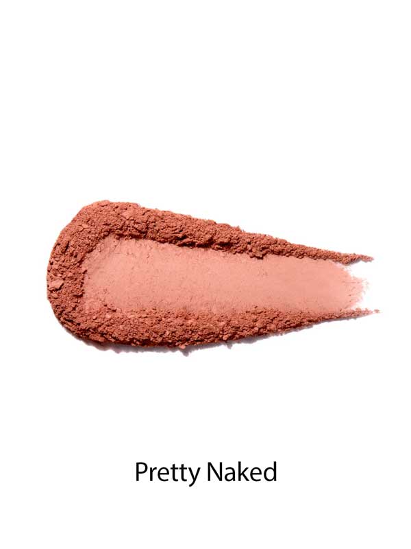 A swatch of matte, peachy-pink 100% Pure Rice Powder Pressed Blush 9g on a white background, labeled Pretty Naked below, highlights a natural flush with buildable coverage.