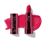 The 100% Pure Fruit Pigmented® Pomegranate Oil Moisturising Lipstick 4.5g in a bright pink “Primrose” shade is shown open beside its cap, with a metallic tube and a lipstick swatch displayed behind it.