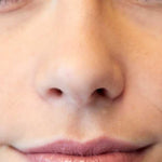 A close-up of a person’s lower face shows smooth skin and closed lips lightly glossed with Luk Beautifood Lip Nourish Lipsticks 3g, with the word "Pure" in the bottom left corner.