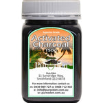 Squat black Pure Eden Activated Charcoal jar with a ribbed white screw lid and a green-bordered label showing palm trees beneath large white lettering.