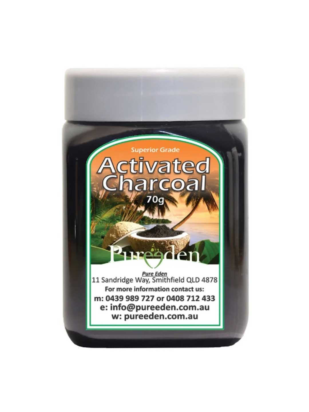 A jar labeled Pure Eden Activated Charcoal 150g sits before a tropical backdrop of palm trees and a waterfall. Made in Australia from coconut shell charcoal, the label includes contact details and an address.