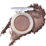 An open compact of 100% Pure Fruit Pigmented® Eye Shadow 2g by 100% Pure reveals shimmery taupe pressed powder, with loose vegan pigment scattered below to showcase its color and texture.