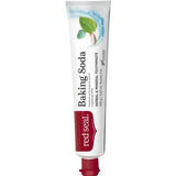 Slender white Red Seal Baking Soda toothpaste tube standing on a small red cap, with large black lettering, a red logo panel and mint leaves near the top.