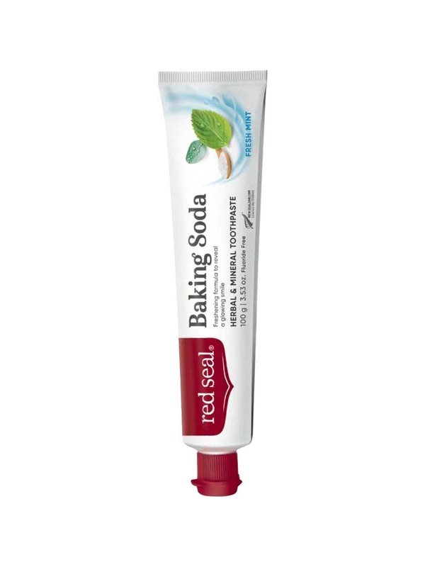 Slender white Red Seal Baking Soda toothpaste tube standing on a small red cap, with large black lettering, a red logo panel and mint leaves near the top.