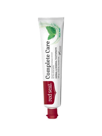 Slender white Red Seal Complete Care toothpaste tube standing on a small red cap, with large black lettering, a red logo panel and green mint leaves near the top.