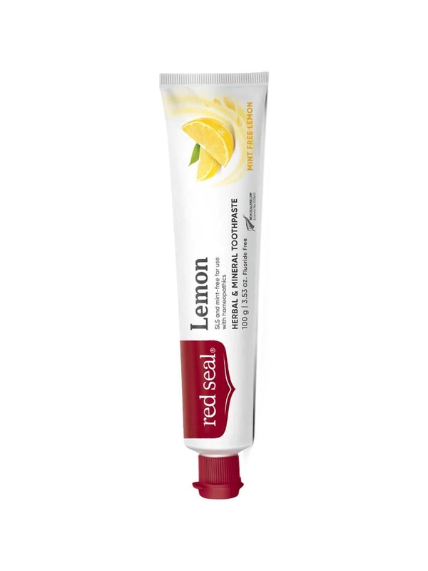 Slender white Red Seal Lemon toothpaste tube standing on a small red cap, with a red logo panel, black lettering and a yellow lemon wedge near the top.