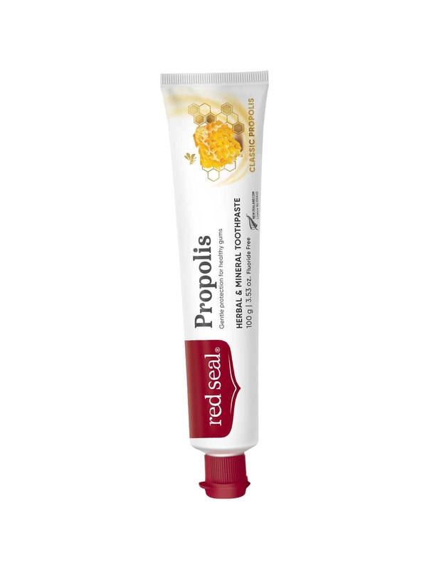 Slender white Red Seal Propolis toothpaste tube standing on a small red cap, with a red logo panel, black lettering and a golden honeycomb illustration near the top.