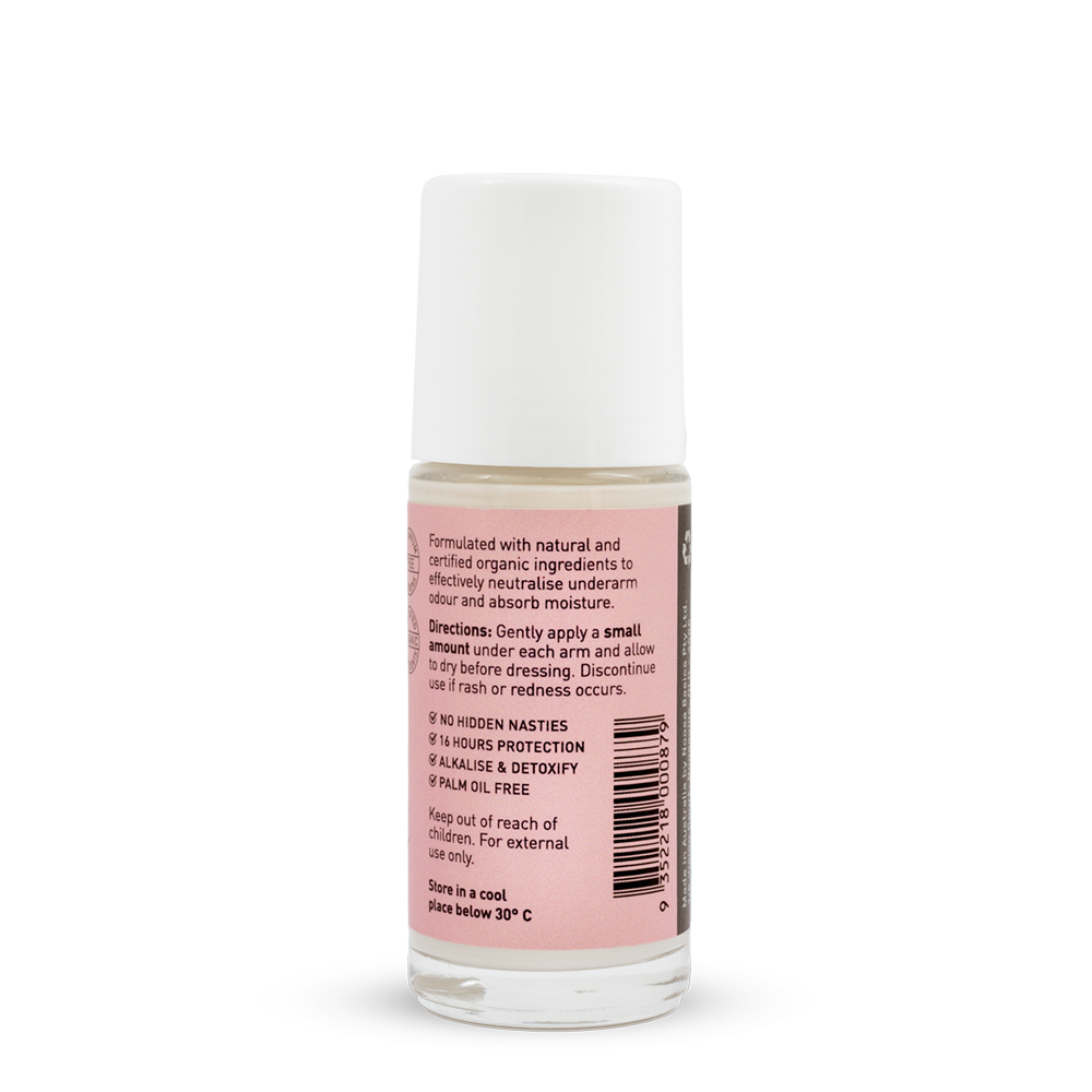 Back of a clear Noosa Basics Rose and Frankincense roll-on deodorant bottle with a white cap, showing small black directions and product information beside a barcode on its pink label.
