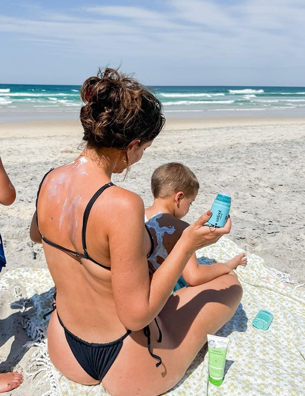 Family using the Wotnot refillable sunscreen roll-on applicator at the beach