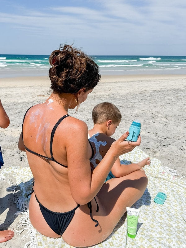Family using the Wotnot refillable sunscreen roll-on applicator at the beach