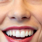 A close-up of a smiling person’s face showcases their white teeth and natural pink lips enhanced by Luk Beautifood Lip Nourish Lipsticks 3g, with the lower part of the word "Rose" visible in the bottom left corner.