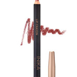 A rose-colored INIKA Organic Lip Crayon 6.7g with a swatch of the long-lasting lip liner shade scribbled behind it; the cap sits beside the crayon. Text below shows "Rose Petal.