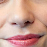A close-up of the lower half of a person’s face with natural makeup and pinkish-red Luk Beautifood Lip Nourish Lipsticks 3g, enriched with nourishing Avocado Oil. The words Ruby Grapefruit appear in the bottom left corner.