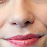 A close-up of the lower half of a person’s face with natural makeup and pinkish-red Luk Beautifood Lip Nourish Lipsticks 3g, enriched with nourishing Avocado Oil. The words Ruby Grapefruit appear in the bottom left corner.
