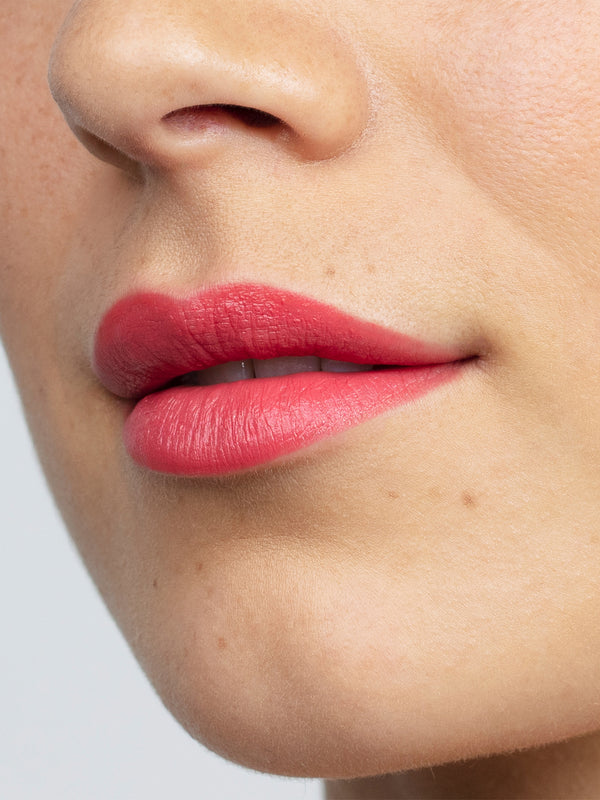Model wearing Antipodes Moisture Boost Natural Lipstick in South Pacific Coral