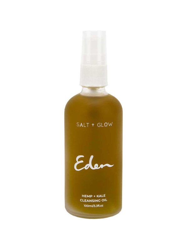 Rounded Salt + Glow Eden cleansing-oil bottle filled with olive-green liquid, with a white pump under a clear cover and the Eden name printed in white script.