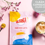 She BANG! Peri Chai Latte pouch styled with a prepared latte and botanicals