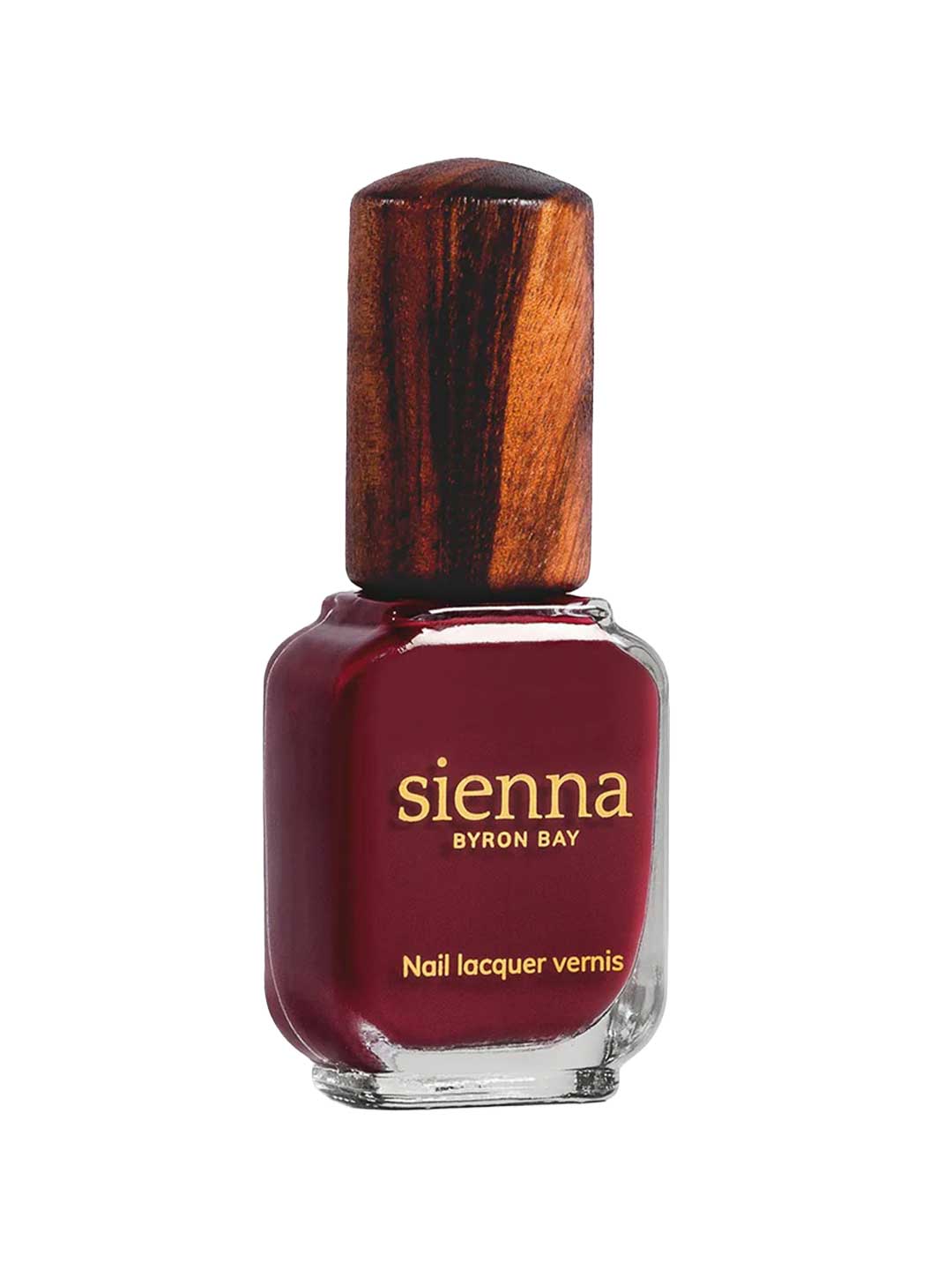 A bottle of Sienna Byron Bay Nail Polish in the shade Promise, featuring a clear glass base, wooden-textured cap, and a gold label with the brand name and product details.