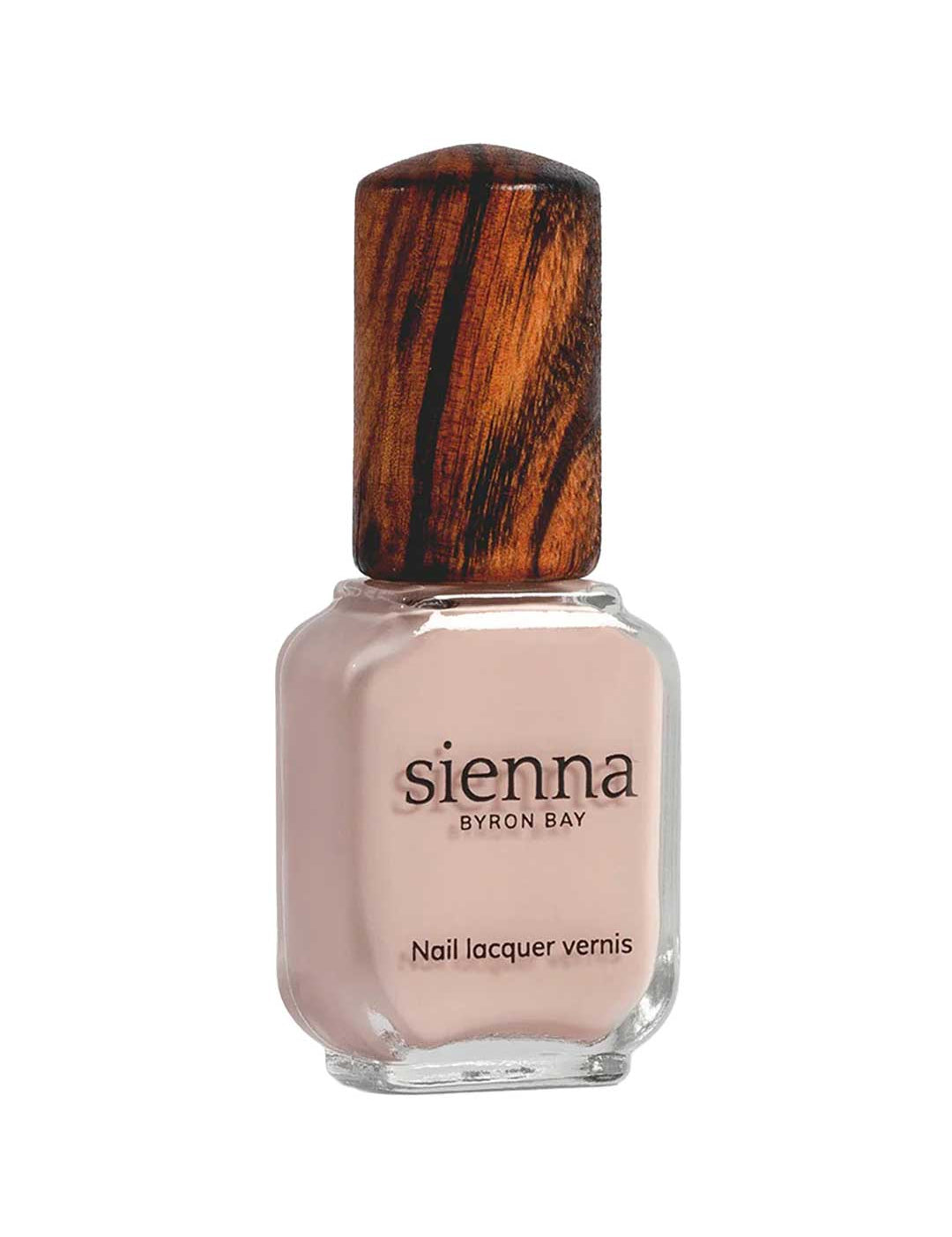 A bottle of Sienna Byron Bay Nail Polish - Posy in a light nude pink shade features a wooden-textured cap and label with the Sienna Byron Bay brand name and product details.
