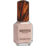 A bottle of Sienna Byron Bay Nail Polish - Posy in a light nude pink shade features a wooden-textured cap and label with the Sienna Byron Bay brand name and product details.
