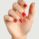 A hand with short, neatly filed nails painted in Sienna Byron Bay’s Heart, a glossy red polish, against a plain light background.