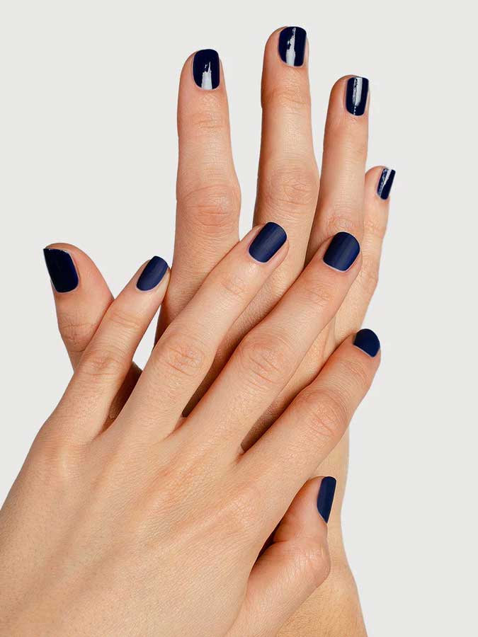Two hands with neatly manicured nails, finished with Sienna Byron Bay Matte Top Coat by Sienna Byron Bay, are crossed over each other against a light background.