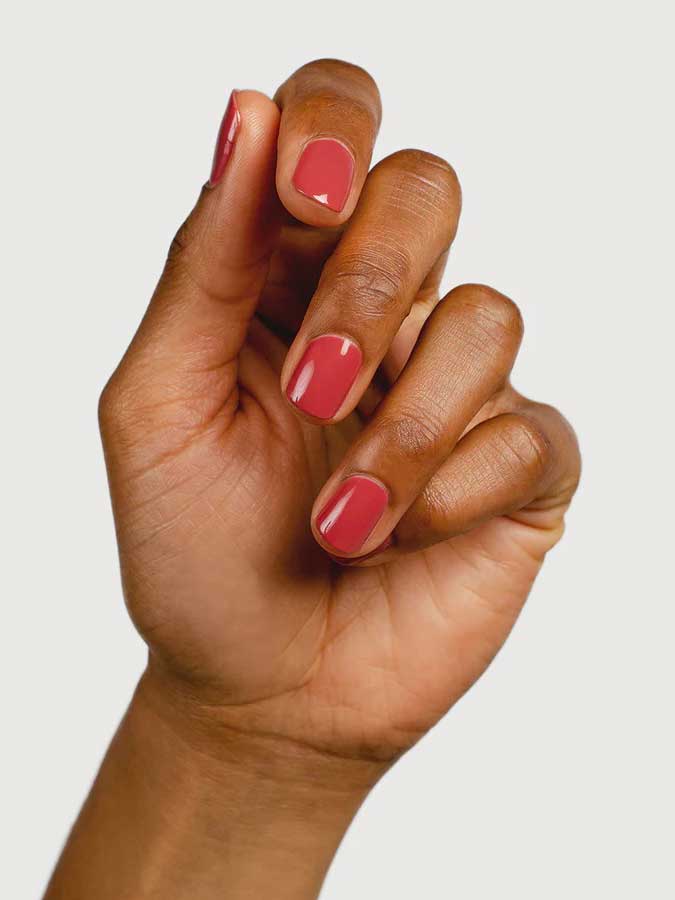 A hand with medium brown skin tone is shown against a white background, displaying neatly manicured nails painted with Sienna Byron Bay Muse by Sienna Byron Bay.