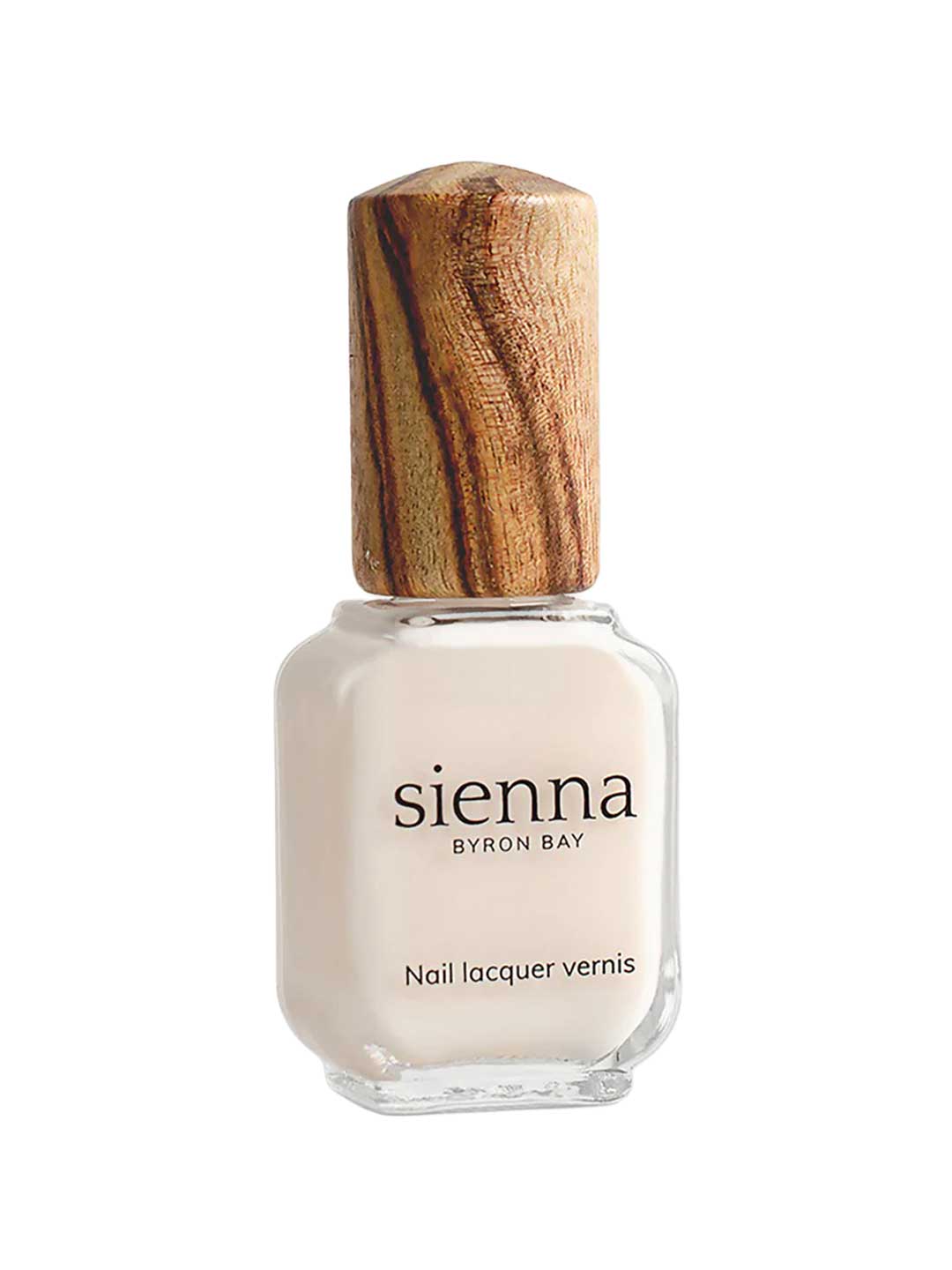A bottle of Sienna Byron Bay - Hope nail lacquer with off-white polish, a wooden cap, and labeled "Nail Lacquer Vernis" from Sienna Byron Bay.