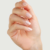 A close-up of a hand with neatly manicured nails painted in Sienna Byron Bay - Hope by Sienna Byron Bay, slightly curled inward against a light, plain background.