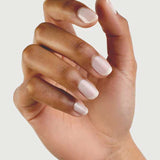 A hand with medium brown skin tone is shown against a plain background, fingers slightly curled. The neatly manicured nails are painted with Sienna Byron Bay - Hope by Sienna Byron Bay, a pale, natural-looking polish.