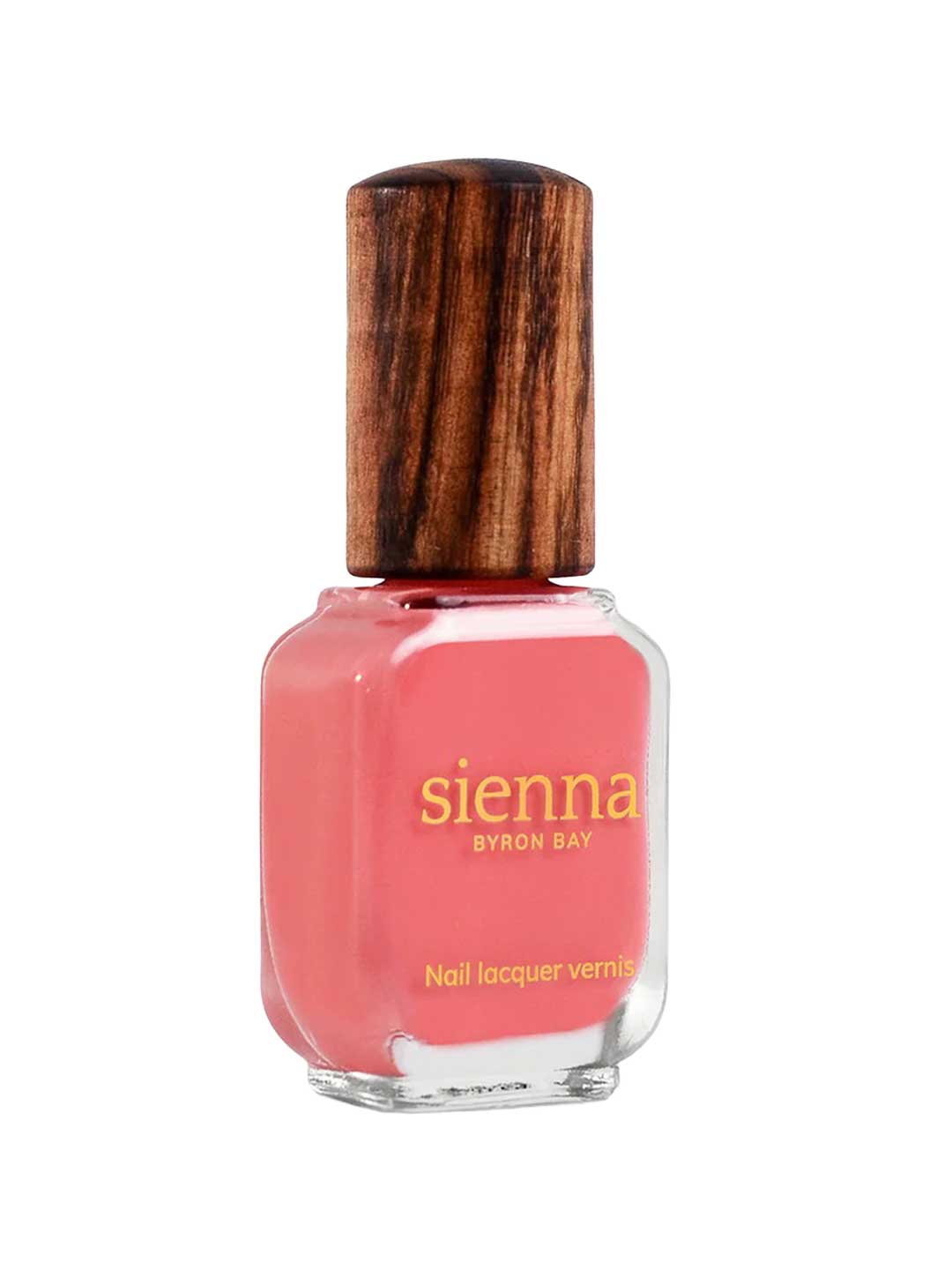 A bottle of Sienna Byron Bay Laughter nail lacquer with a pink shade and wooden cap, featuring gold text on the front of the glass container.