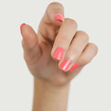 A hand with fingers slightly bent displays fingernails painted in Sienna Byron Bay Laughter, a glossy pink shade by Sienna Byron Bay, against a plain white background.