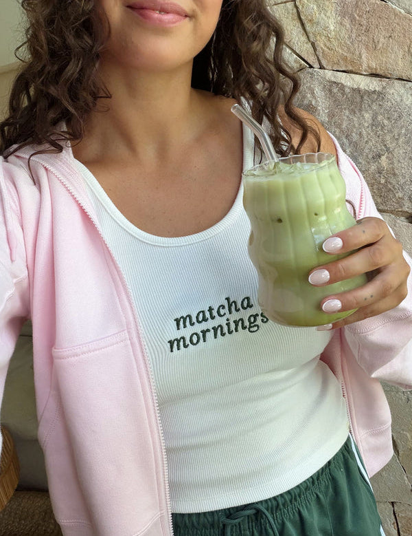 Woman holding an iced Nutra Naturals Collagen Strawberry Matcha Latte