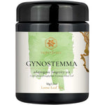 A black plastic jar of Superfeast Gynostemma adaptogenic longevity tea, featuring a white label with a light green watercolor design and gold accents.