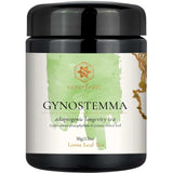 A black plastic jar of Superfeast Gynostemma adaptogenic longevity tea, featuring a white label with a light green watercolor design and gold accents.