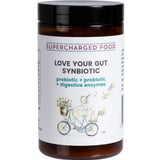 A brown jar labeled Supercharged Food Love Your Gut Synbiotic Powder 120g, featuring prebiotics, probiotics, and digestive enzymes. The label shows a person riding a bicycle with flowers.