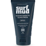 Dark navy Surfmud Ocean Addicts SPF30 sunscreen tube standing on its matching flip-top cap, with bold stacked white 'surf mud' lettering above the product details.