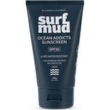 Dark navy Surfmud Ocean Addicts SPF30 sunscreen tube standing on its matching flip-top cap, with bold stacked white 'surf mud' lettering above the product details.