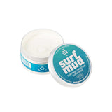 An open tin of Surfmud Surfbaby Sensitive Sunscreen SPF30 (100g) with the teal lid off to the side, showing white cream inside. The plastic-free tin highlights this sensitive sunscreen's gentle formula.