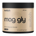 A beige and black plastic tub of Switch Nutrition Mag Gly, featuring a black lid and a beige label with black text, on a solid white background.