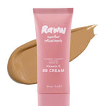 A pink tube of RAWW Vitamin C BB Cream 30ml stands before a tan smear, highlighting its shade. This hydrating balm helps deliver a luminous complexion.