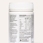 Rear view of the white The Beauty Chef Daily Supergreens Pineapple jar beneath its ribbed white lid, showing a nutrition table, serving instructions and product information in small black print.