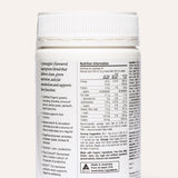 Rear view of the white The Beauty Chef Daily Supergreens Pineapple jar beneath its ribbed white lid, showing a nutrition table, serving instructions and product information in small black print.