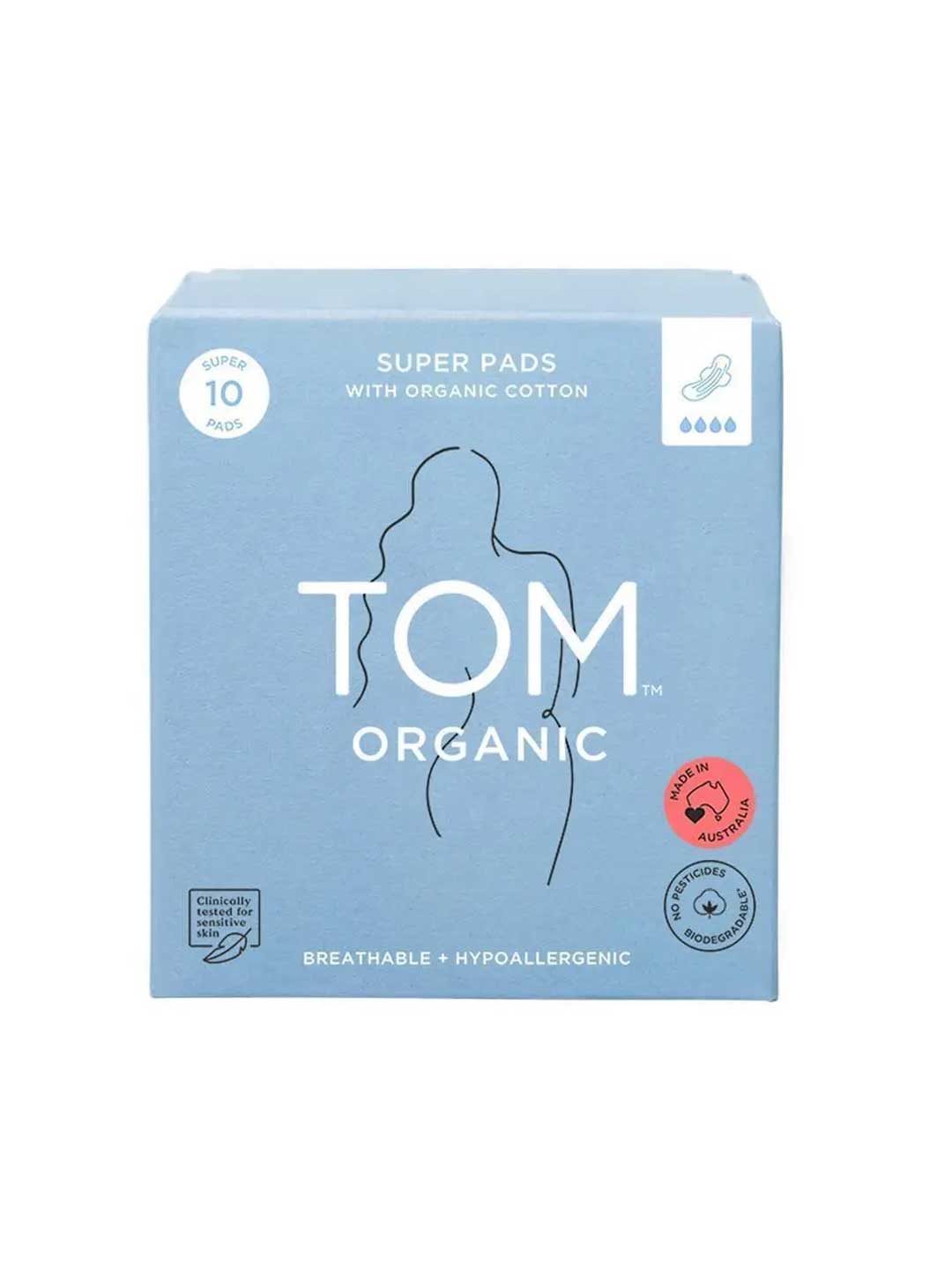 A blue box of TOM Organic Pads Extra Super 10pk features organic cotton pads, a woman’s body outline, and labels for breathability, hypoallergenic, and chemical-free benefits.
